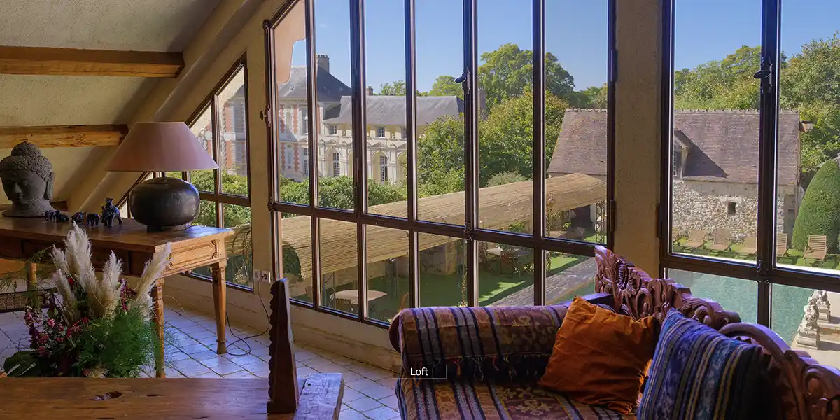 de loftlounge kijkt uit op het zwembad en het kasteel